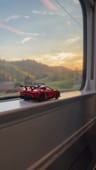 A toy car on a train window ledge turning into the real car in a tunnel