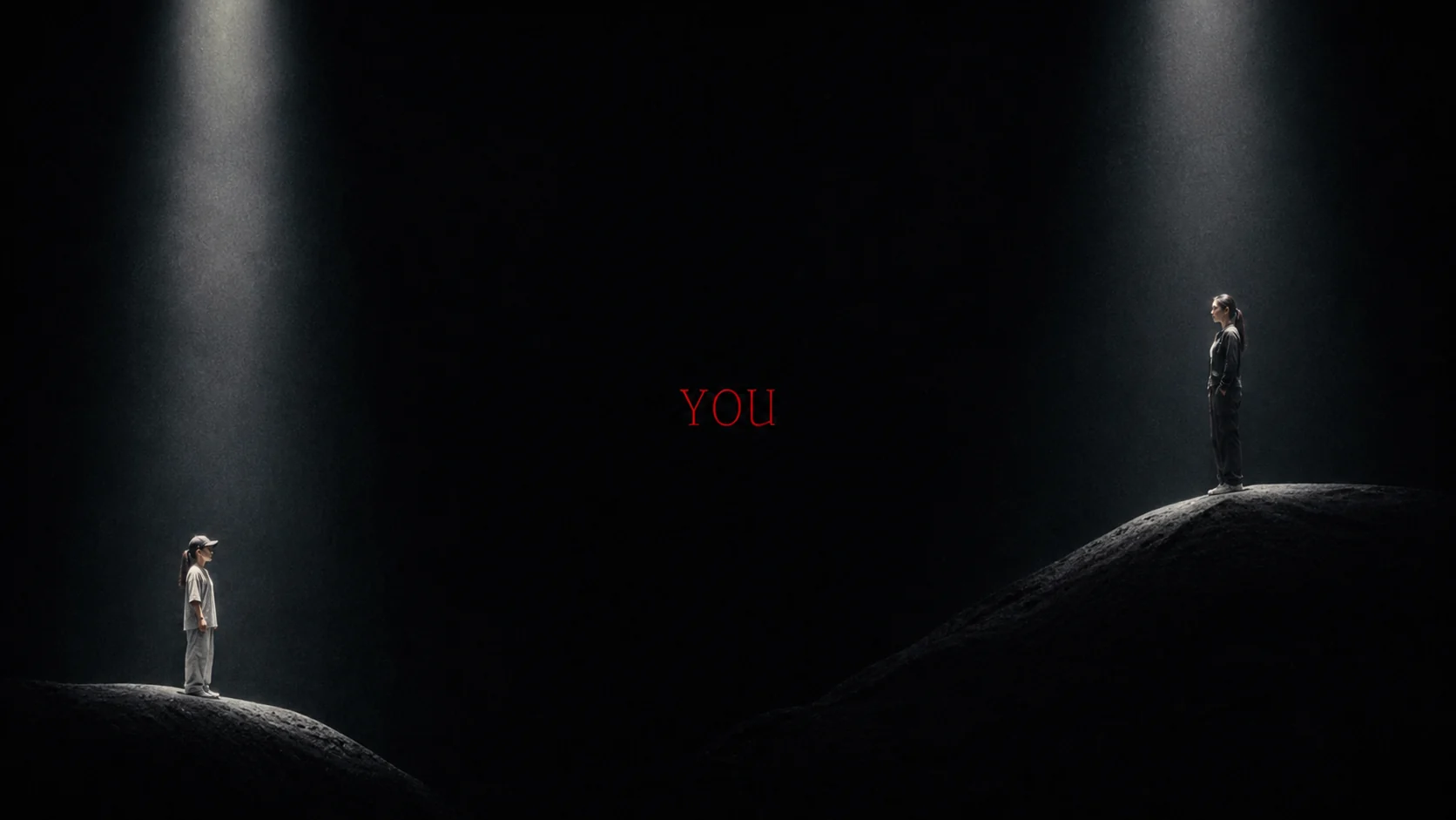 Younger and adult versions of the same woman facing each other on separate mounds beneath two spotlights